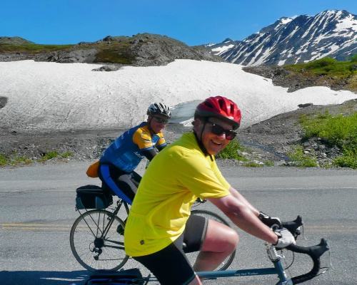 cyclists passing snowfields