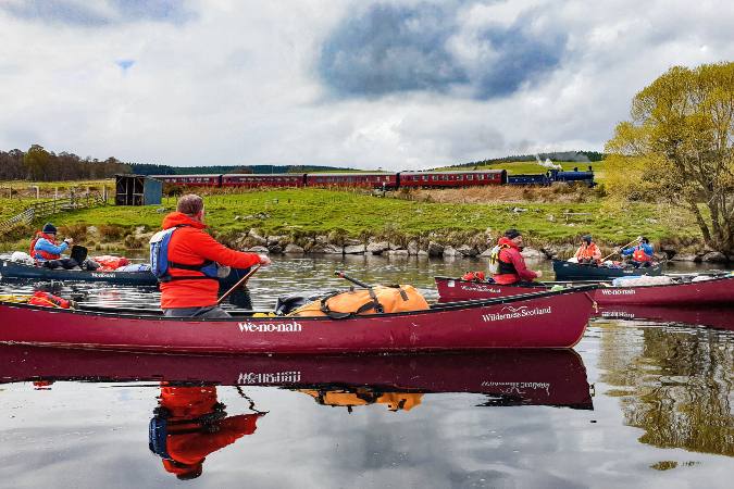 steam train passing canoeists on Spey River