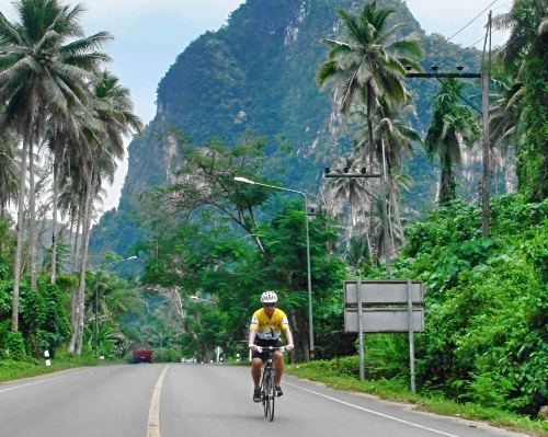 cyclist on road through karst landscape